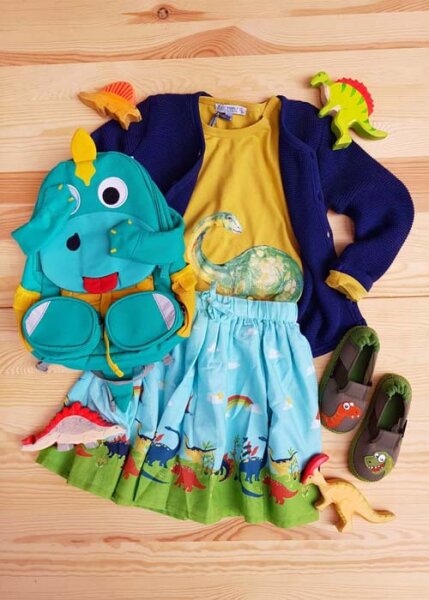 Flatlay mit nachhaltiger Kinderkleidung unter dem Motto Dino