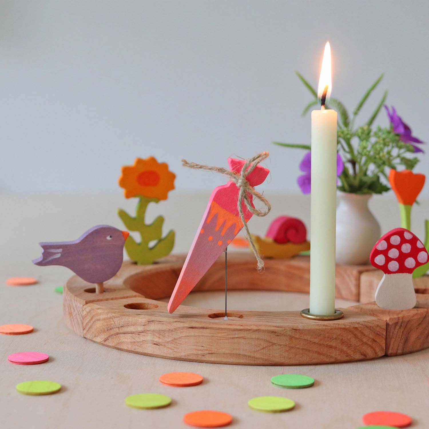 Nachhaltige Dekoration zur Einschulung mit Grimms: Steckring mit Steckfiguren Schultüte, Vogel, Blumen, Glückspilze und Kerzen. Dazu buntes Holzkonfetti.
